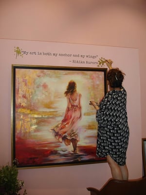Woman standing in front of painting of woman