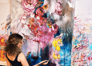 Girl painting in front of large canvas of bold colors flowers