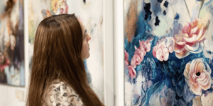 woman looking at floral painting