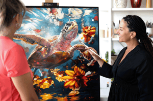 woman standing in fron of tutle painitng bluw water and yellow flowers